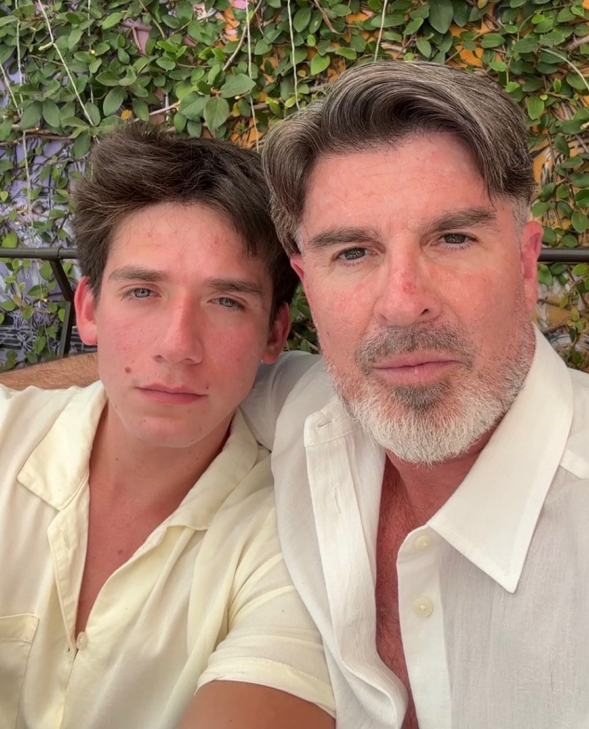 Two men close together, looking at the camera
